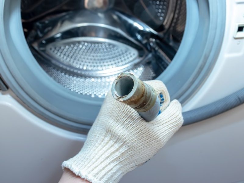 Hand,Of,A,Plumber,Holding,A,Broken,Flexible,Drain,Hose